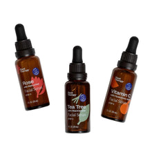 Three amber facial serum dropper bottles labeled Rose, Tea Tree, and Vitamin C