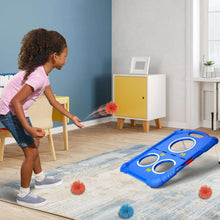 Child using blue ball toss board with pom balls on a floor mat