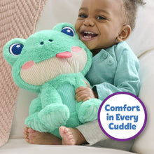 Green frog plush stuffed animal held by smiling baby in a light green outfit