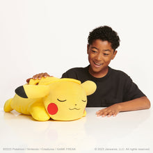 Sleeping Pikachu plush with closed eyes and red cheek patches, yellow stuffed toy