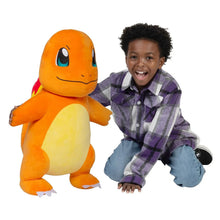 Charmander jumbo plush next to a child wearing a plaid shirt and jeans