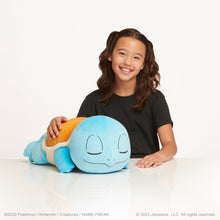 Sleeping Squirtle plush held by smiling child, blue body with orange shell