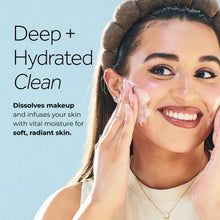 Woman applying white facial cream to her cheek with fingertips