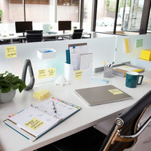 Canary yellow sticky notes on office desk with stationery and desk accessories