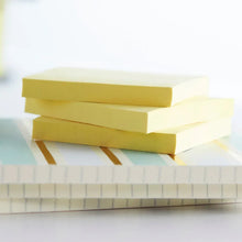 Canary yellow sticky note pads stacked together