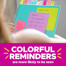 Neon sticky note tabs on a spiral notebook, showing pink and yellow note blocks