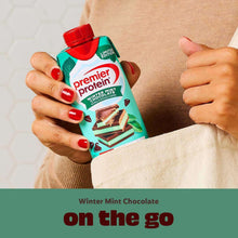 Premier Protein winter mint chocolate shake carton in hands, red cap visible