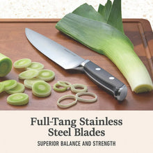 Stainless steel chef knife and utility knives with black handles on a cutting board