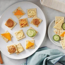 Assorted saltine crackers topped with cheese, chutney, and sliced cucumber