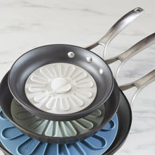 Silicone multi-function lid, white radial shape on a frying pan