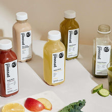 Pressed Juicery juice cleanse bottles on white table, green and amber bottles with caps