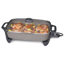 Electric ceramic skillet with glass lid, black handles and feet, holding cooked food