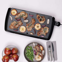 Presto electric griddle with sliced potatoes, onions, and herbs on dark plate