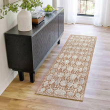 Area rug with light gray and rust geometric motif on cream background, bordered edge.