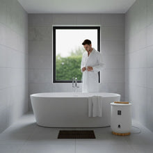 Compact white towel warmer with wooden base on bathroom floor, showing digital display