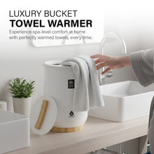 White towel warmer with wooden base, open lid, and light gray towel