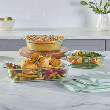 Clear deep glass baking dishes filled with assorted prepared food