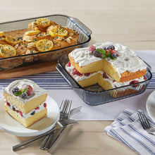 Scalloped tinted glass baking dishes with airtight lids holding assorted desserts