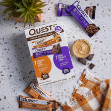 Protein bar variety pack with wrapped bars and a scoop of peanut butter spread