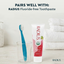 Blue kids toothbrush beside fluoride-free toothpaste tube in a value set