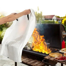 White fire blanket being pulled over an outdoor grill fire