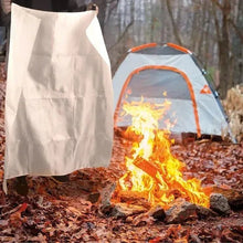Deployed white fire blanket covering flames outdoors
