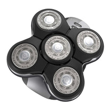 Electric head shaver close-up with four circular foil drums on black head