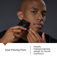 Electric foil shaver held near chin, black handle