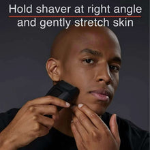 Electric foil shaver held against skin near chin