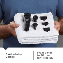 Men's trimmer and comb attachments resting on a folded towel