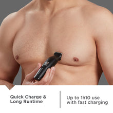 Black trimmer shaving chest area with comb attachment