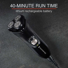 Black rotary shaver resting on textured surface with power button visible