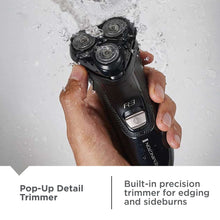Men's rotary shaver in use under water with hands holding the textured handle