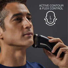 Rotary shaver in use on a man’s cheek, black and silver handheld design