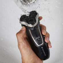 Rotary shaver held under running water, black body with silver shaving head