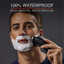 Rotary shaver with shaving cream on a man’s face, black and silver trimmer