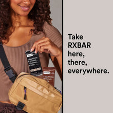 Person holding an RXBAR protein bar with a light tan snack pouch