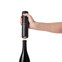 Electric wine aerator device held by hand, black body with gold top
