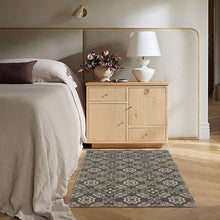 Dark gray accent rug with repeating white geometric medallion pattern, flat woven style.
