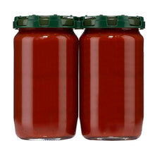 Two glass jars of marinara sauce with green caps, maroon red sauce inside