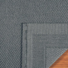 Indoor/outdoor rug edge detail showing silver-gray border and woven texture