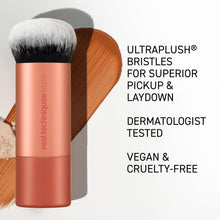Makeup brush with white bristles on a rose-gold barrel and handle.