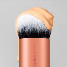 Close-up of a blending brush head with white bristles and rose-gold handle.
