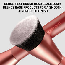 Dense flat-headed makeup brush with black bristles on rose-gold handle