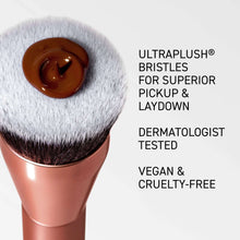 Round makeup brush with soft bristles holding brown gel on rose-gold handle