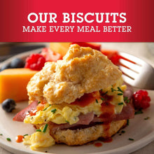 Cheddar biscuits stacked with melted cheese and herb garnish on a plate