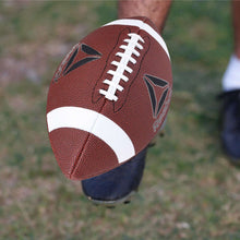 Brown football with white laces and a white stripe panel, angled view