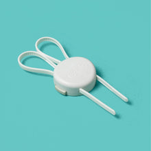Set of white and clear strap locks with round base and brown pull tabs