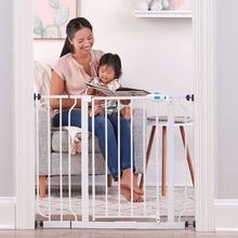 Extra wide white baby gate with walk-through door, set in doorway for toddler safety