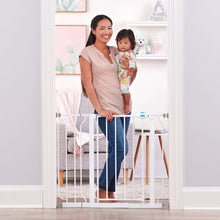 White extra wide baby gate installed at doorway with walk-through door latch visible